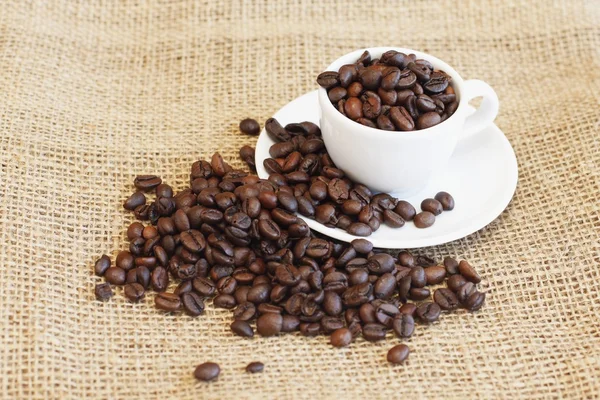 Taza con granos de café en el saco —  Fotos de Stock