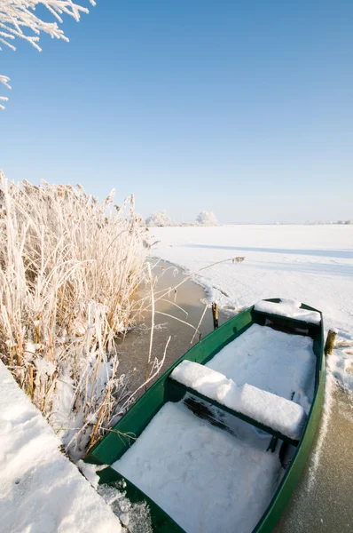 Zielony łódź na lodzie w krajobraz zimowy — Zdjęcie stockowe
