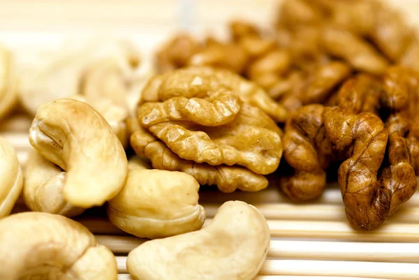 stock image Cashew and walnuts over bamboo mat