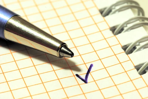 Uma caneta e uma marca de carraça — Fotografia de Stock
