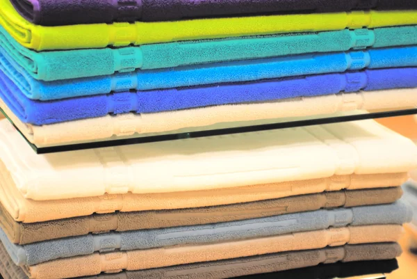 Stapel van gekleurde handdoeken op de planken — Stockfoto