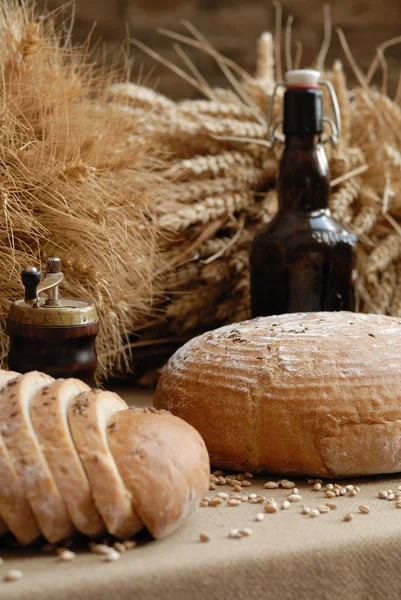 Свіжий запечений хліб зі стеблами пшениці та пляшкою ведмедя — стокове фото