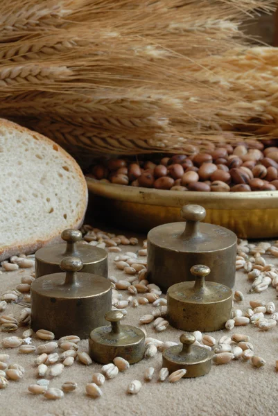 Weights with bread, soybeans and stems of wheat — Stock Photo, Image