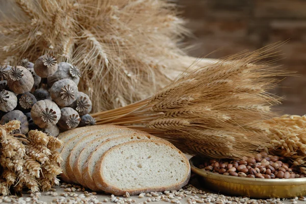 Freshly baked bread with stems of wheat and soybeans — Stock Photo, Image
