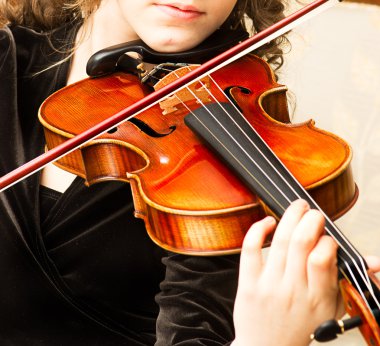 Young woman practicing her violin clipart