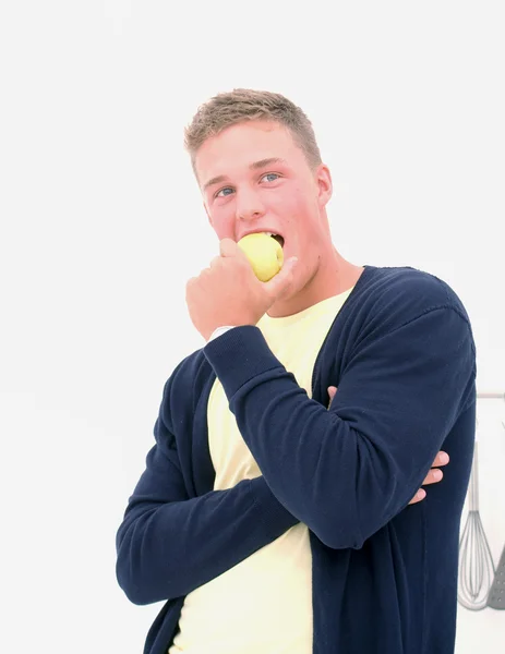 Beau jeune homme mangeant une pomme — Photo