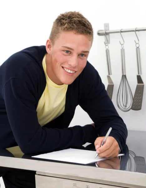 Young man writing down recipe — Stock Photo, Image