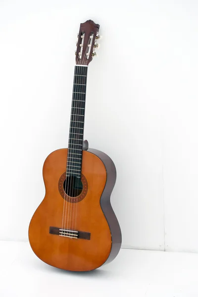 Guitarra acústica por parede branca — Fotografia de Stock