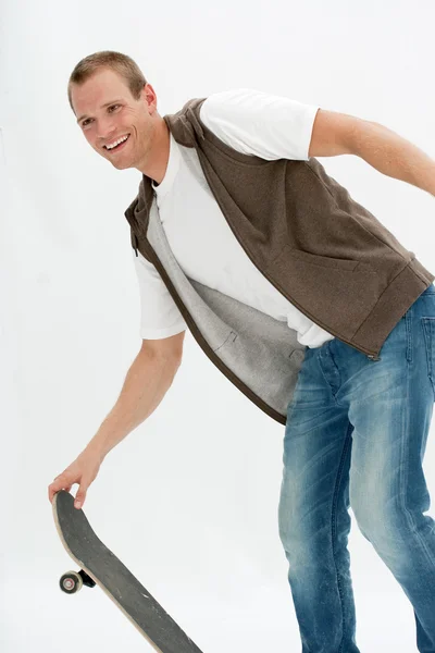 Привлекательный молодой человек со скейтбордом — стоковое фото