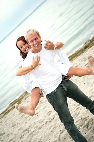 Young couple having fun on the beach — Stock Photo, Image