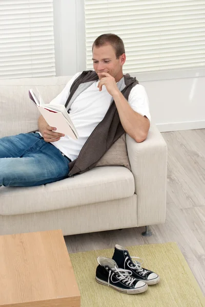 Pohledný mladý muž čtení — Stock fotografie