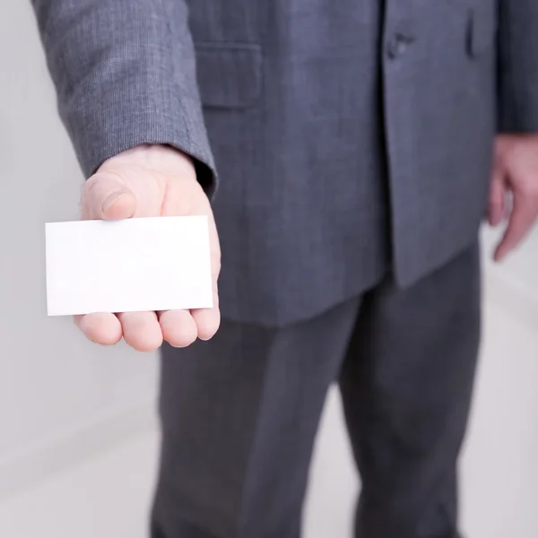 Businessman holding out a blank card — Stock Photo, Image