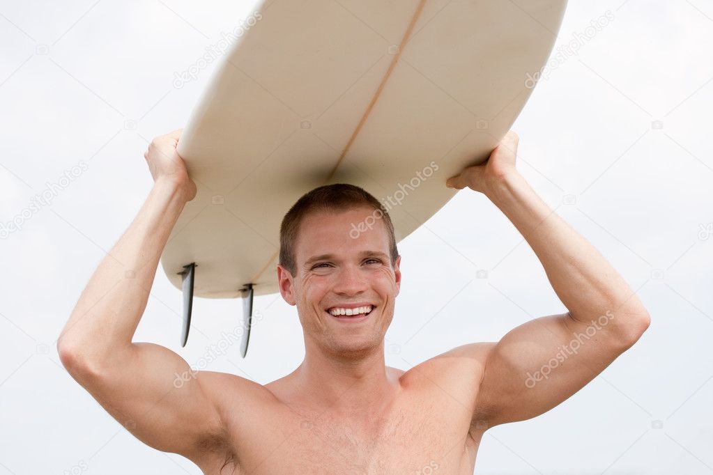 Fit young man with surfboard