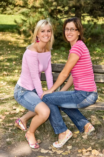 Αδελφές που κάθεται σε ένα παγκάκι — Φωτογραφία Αρχείου