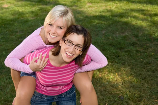 Happy girl being piggybacked by her sisters — Stock Photo, Image