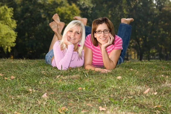 Дві сестри лежать на траві — стокове фото