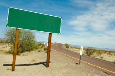 Blank Green Road Sign On Desert Road clipart