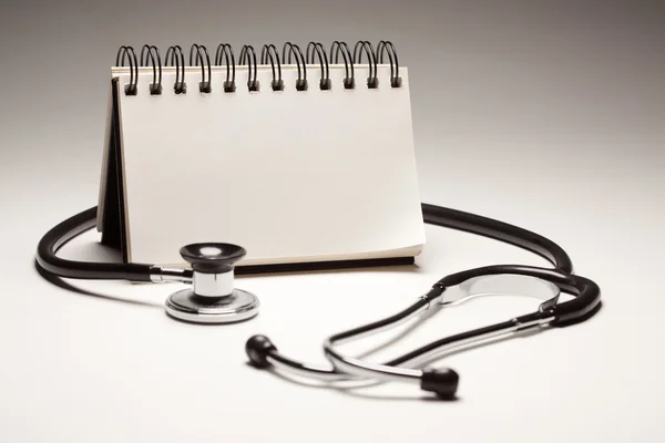 Boş bir not defteri ve siyah stetoskop — Stok fotoğraf