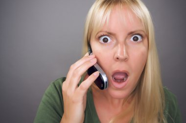 Stunned Blond Woman Using Cell Phone Aga clipart