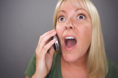 Stunned Blond Woman Using Cell Phone clipart