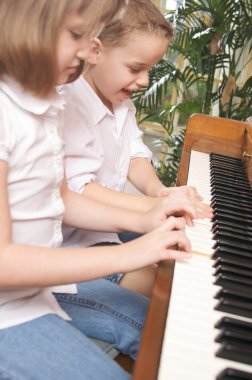 Brother and Sister Playing the Piano Together clipart