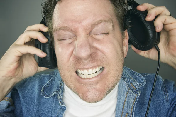 헤드폰을 착용 하는 충격 을된 사람이 — 스톡 사진