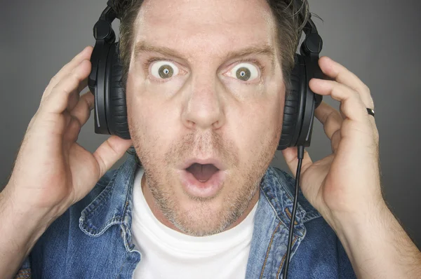 Zszokowany mężczyzna nosi słuchawki — Zdjęcie stockowe