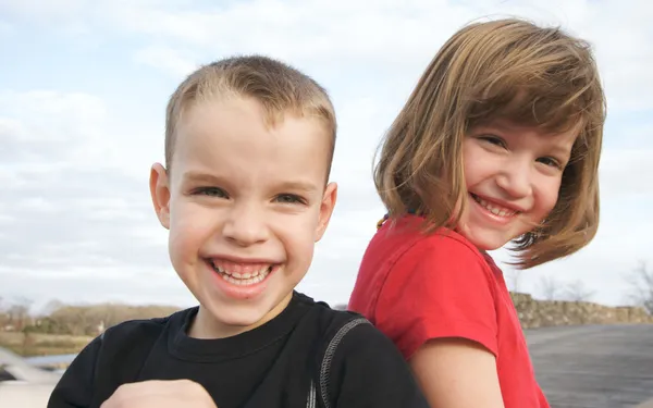 Dos niños sonríen para la cámara en el parque — Foto de Stock
