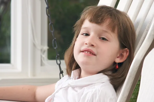 Nettes Mädchen posiert auf einer Veranda-Schaukel — Stockfoto
