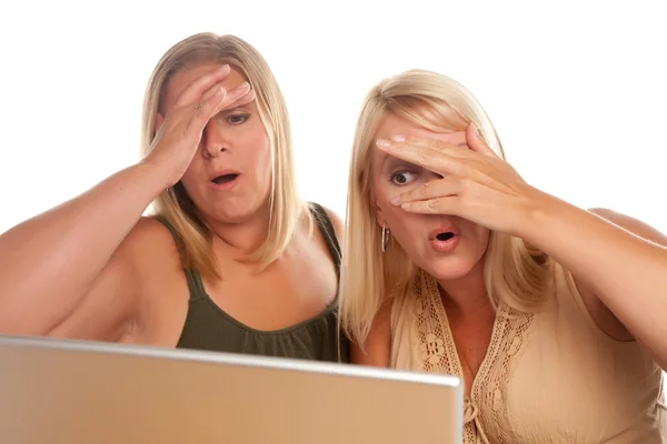 Dwie kobiety wstrząśnięty przy użyciu laptopa na białym tle — Zdjęcie stockowe
