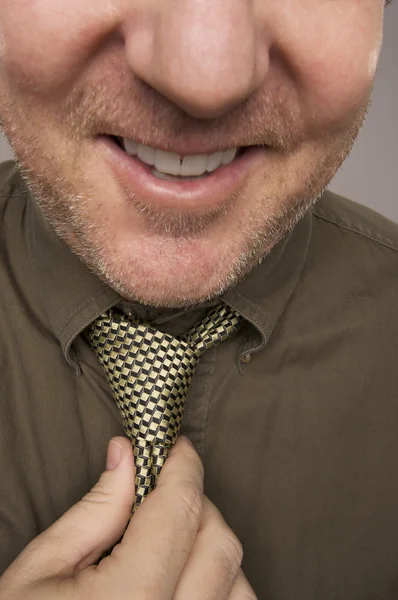 Усміхнений чоловік фіксує краватку — стокове фото