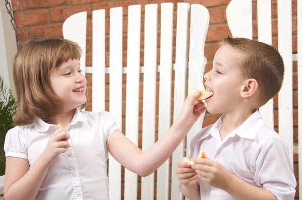 Syster och bror mata varandra frukt — Stockfoto