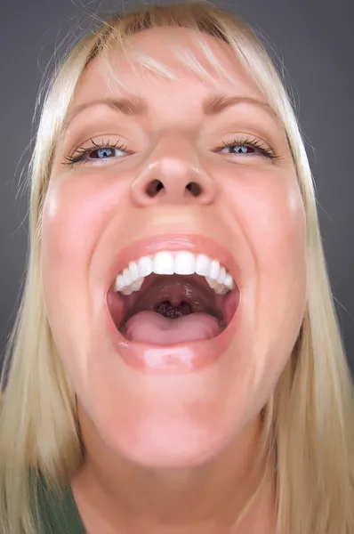Skrattande blond kvinna med roliga ansikte — Stockfoto