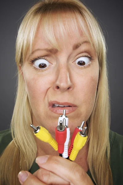 Mulher confusa segurando cabos eletrônicos — Fotografia de Stock
