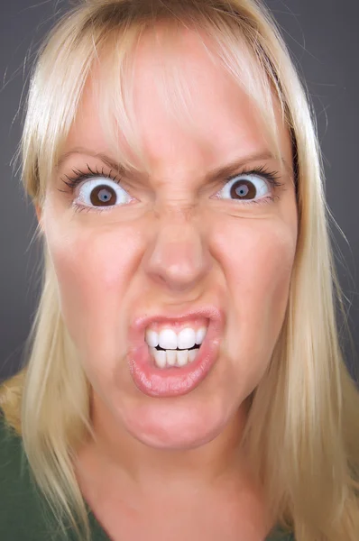 Irritado loira mulher contra cinza — Fotografia de Stock
