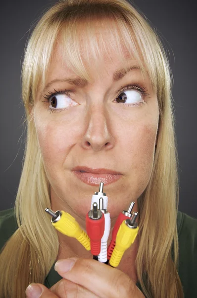 Mulher confusa segurando cabos eletrônicos — Fotografia de Stock