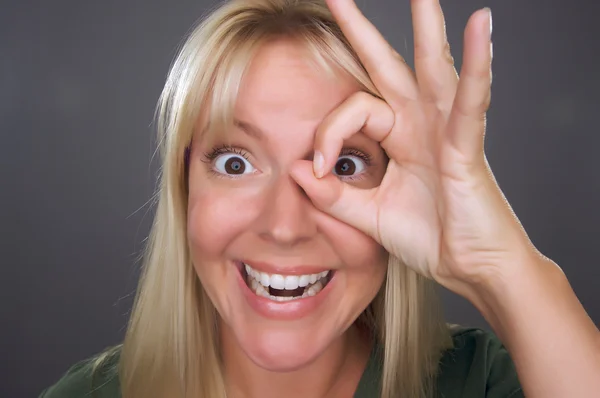 Frau mit Okay-Zeichen vor dem Gesicht — Stockfoto