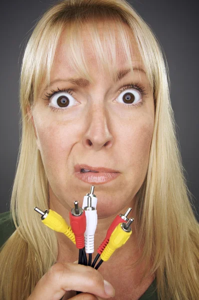 Femme confondue tenant des câbles électroniques — Photo