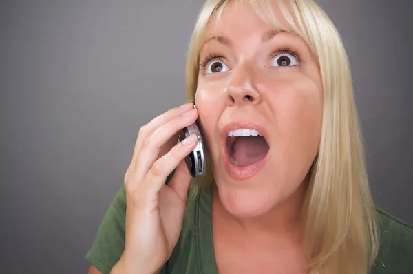Chockad blond kvinna med hjälp av mobiltelefon — Stockfoto