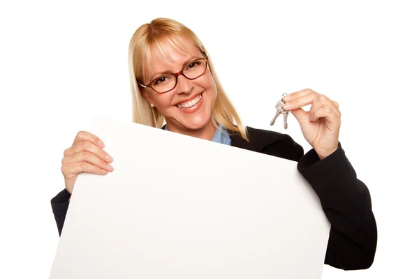 Mujer feliz sosteniendo llaves y signo en blanco —  Fotos de Stock