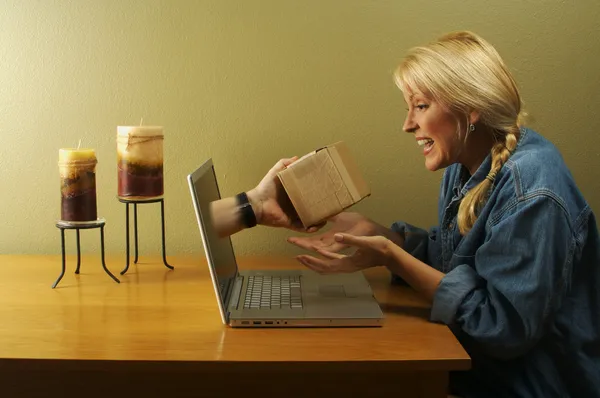 Пакет через экран ноутбука и девушка — стоковое фото