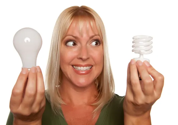 Mulher detém poupança de energia e lâmpada regular — Fotografia de Stock