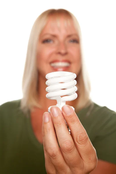Девушка держит энергосберегающую лампочку — стоковое фото
