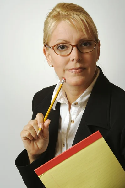 Mulher bonita pensa com lápis e bloco de notas — Fotografia de Stock