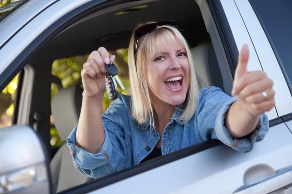 Gelukkige vrouw in nieuwe auto met toetsen — Stockfoto