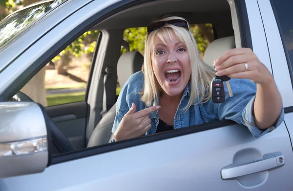 Opgewonden meisje in nieuwe auto met toetsen — Stockfoto