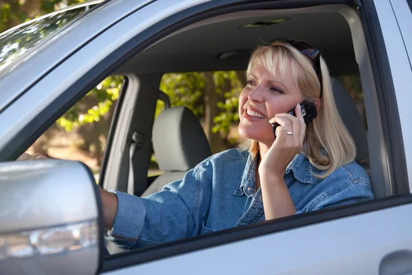 Женщина за рулём с помощью мобильного телефона — стоковое фото