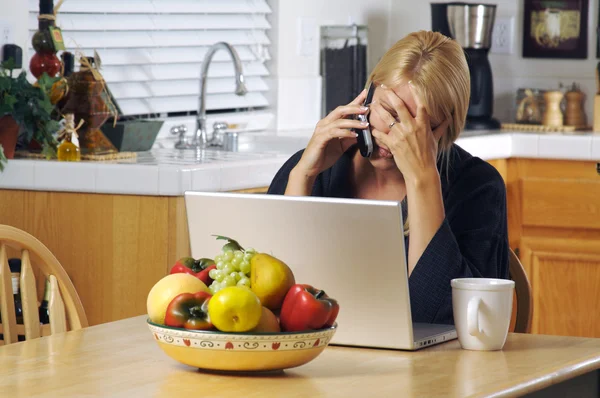 Mujer estresada usando teléfono y computadora portátil — Foto de Stock