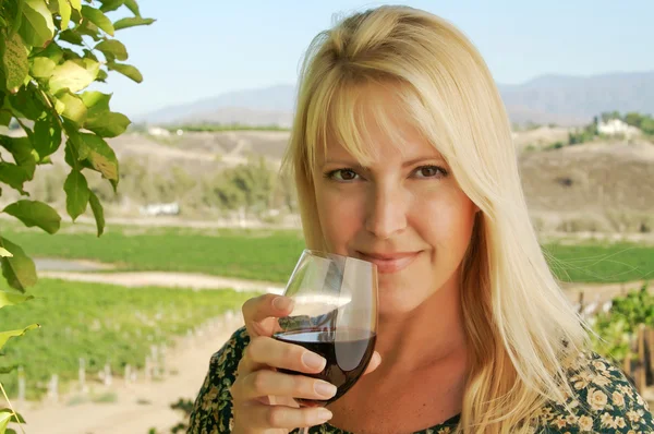 Atraktivní dívka doušky vína na vinici — Stock fotografie