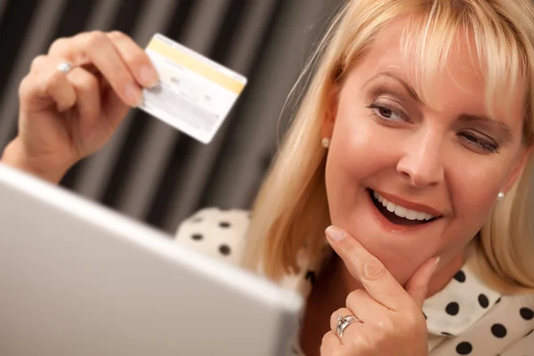 Žena na svém laptopu, drží kreditní kartu — Stock fotografie